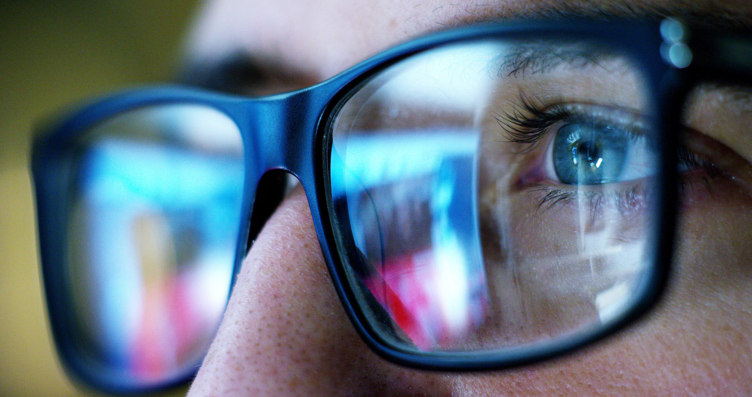 Close-up of a person's eye reflecting data on a screen, symbolizing the focus and precision of centralized data systems in the insurance industry